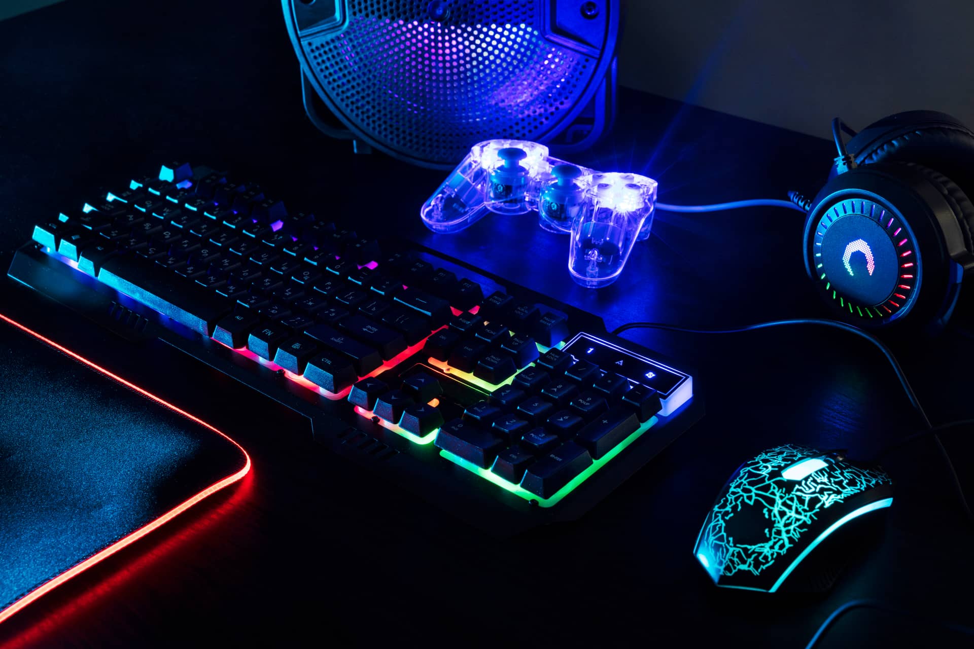 view of illuminated neon gaming keyboard setup and controller